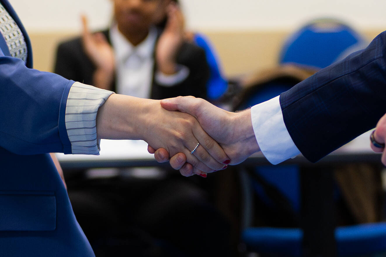 Close-up of two students shaking hands at a Student Senate General Assembly